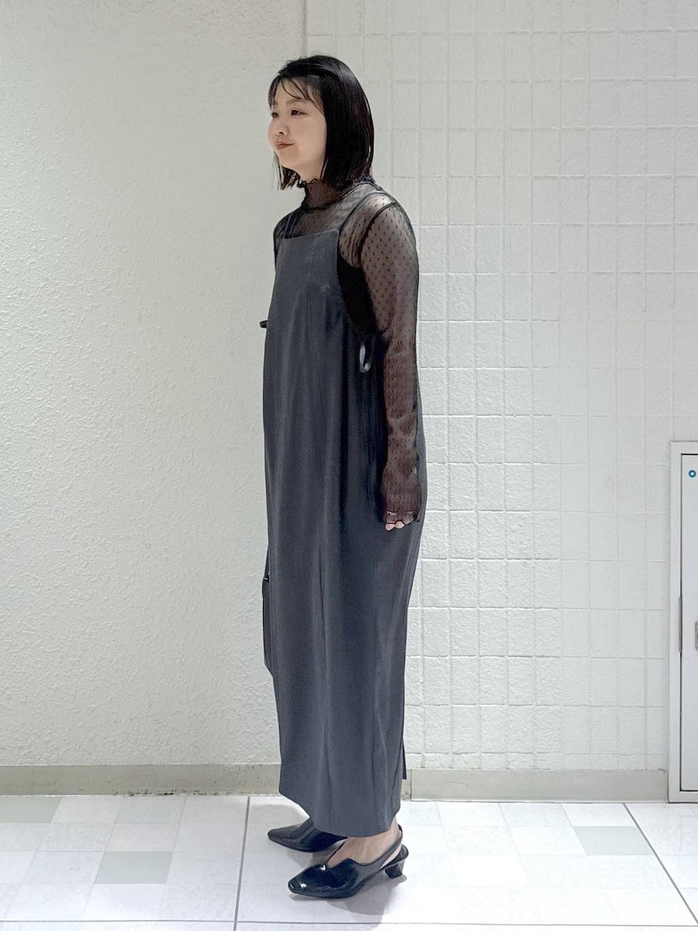 ブラック系のTシャツ/カットソー、グレー系のワンピース、ブラック系のパンプスを着用したレディースの春コーディネートの4枚目の写真