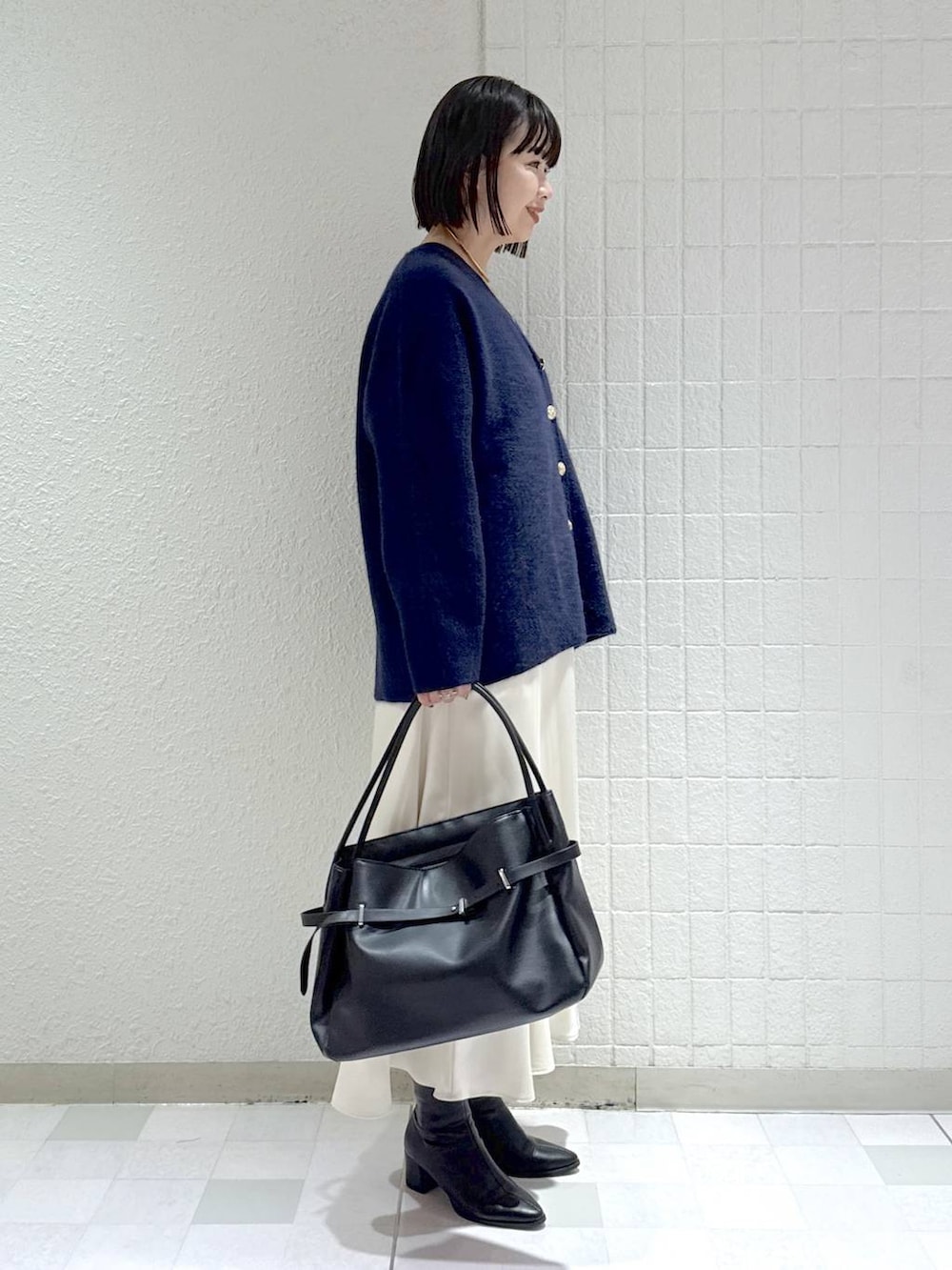 ブルー系のカーディガン/ボレロ、ブラック系のブーツ、ホワイト系のワンピースを着用したレディースの秋コーディネートの3枚目の写真