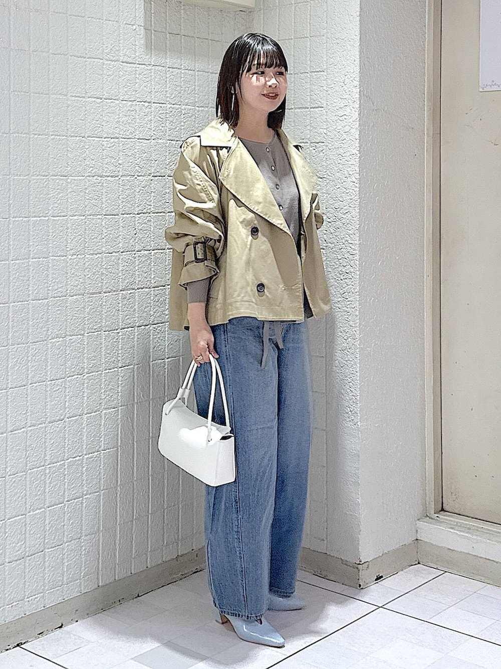 ブルー系のデニムパンツ、グレー系のカーディガン/ボレロ、ベージュ系のトレンチコートを着用したレディースの冬コーディネートの3枚目の写真