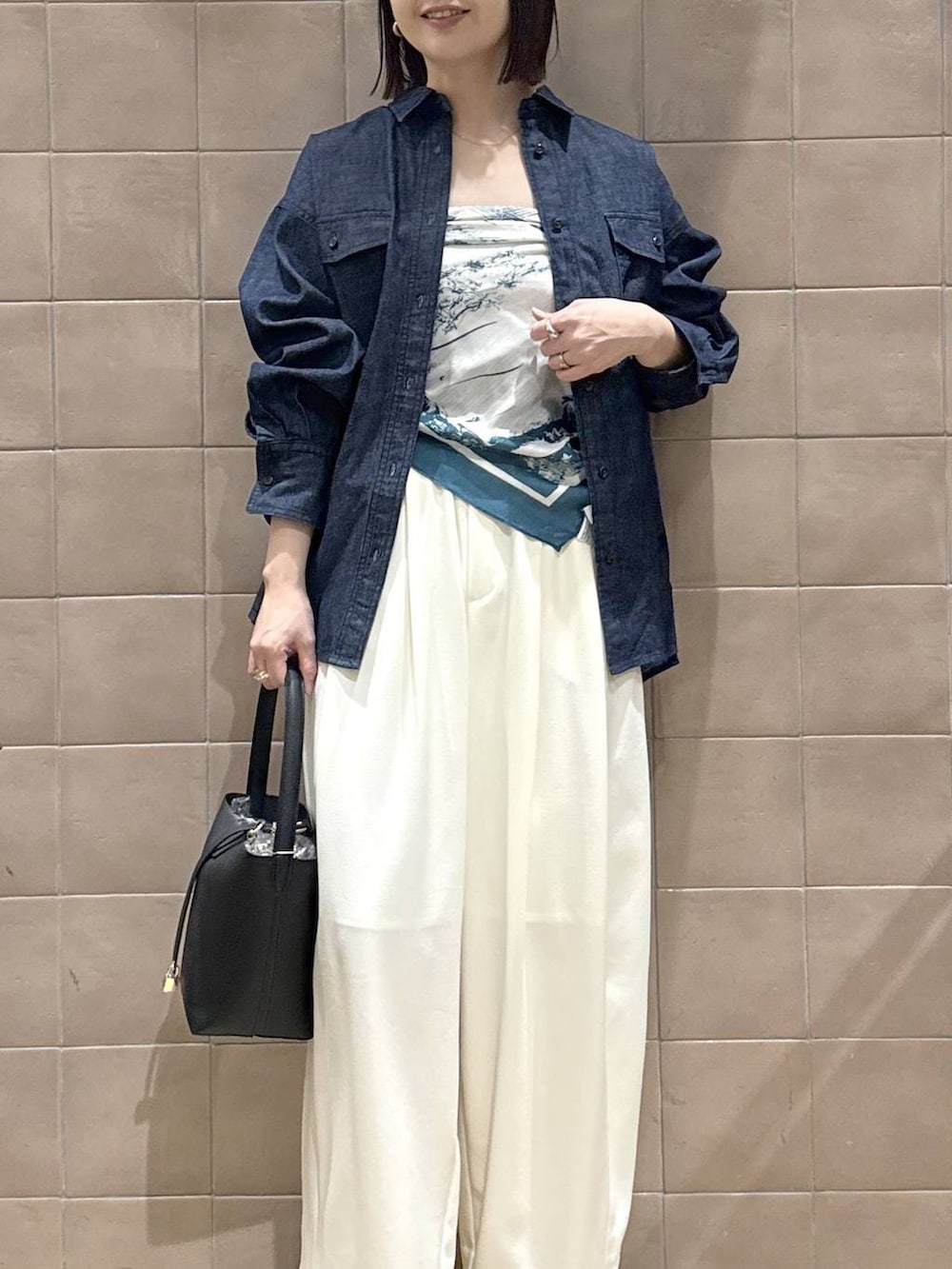 ホワイト系のスラックス、ブラック系のパンプス、ブラック系のショルダーバッグを着用したレディースの春コーディネートの7枚目の写真