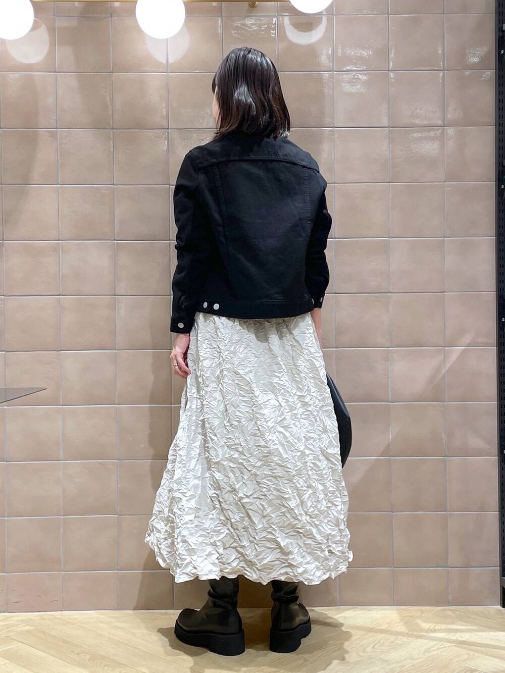 ブラック系のデニムジャケット、ブラック系のハンドバッグ、ブラック系のシャツ/ブラウスを着用したレディースの秋コーディネートの4枚目の写真