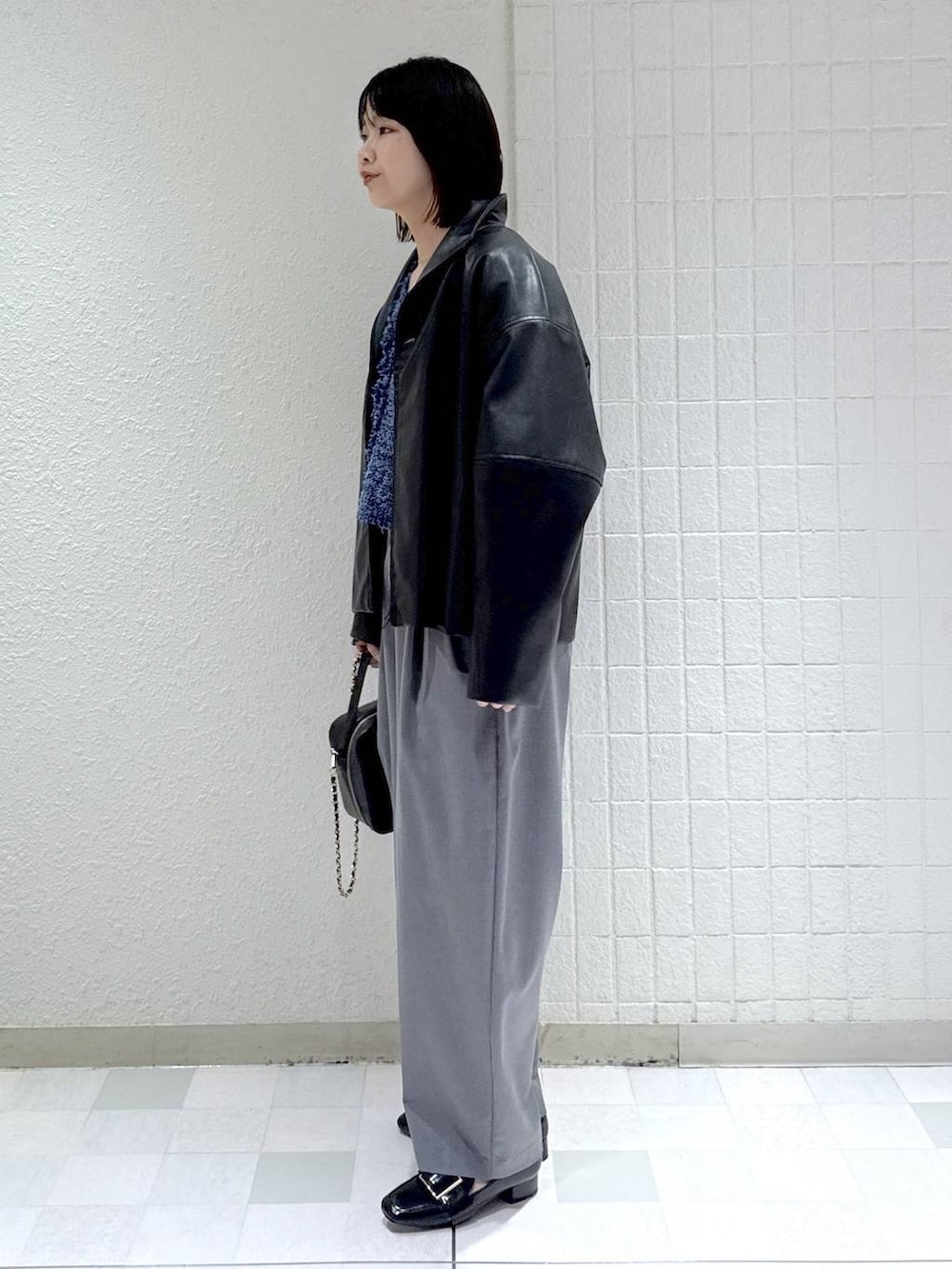 ホワイト系のタンクトップ、ブラック系のローファー、ブルー系のカーディガン/ボレロを着用したレディースの春コーディネートの4枚目の写真