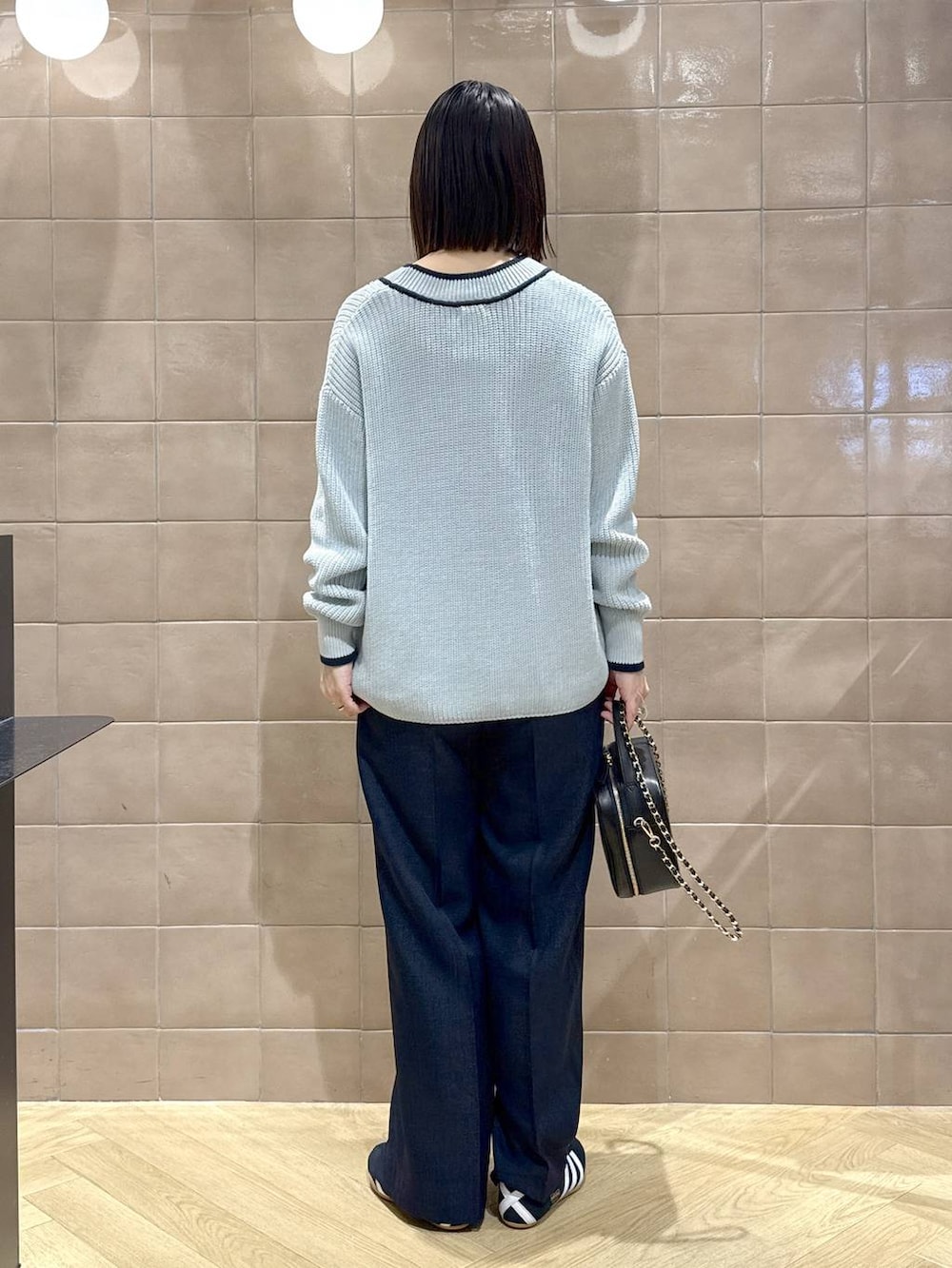 ブラック系のスニーカー、ブルー系のスラックス、ブルー系のニット/セーターを着用したレディースの冬コーディネートの4枚目の写真