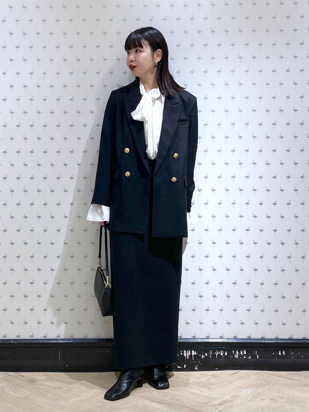 ブラック系のショルダーバッグ、ブラック系のブーツ、ブラック系のスカートを着用したレディースの冬コーディネートの4枚目の写真