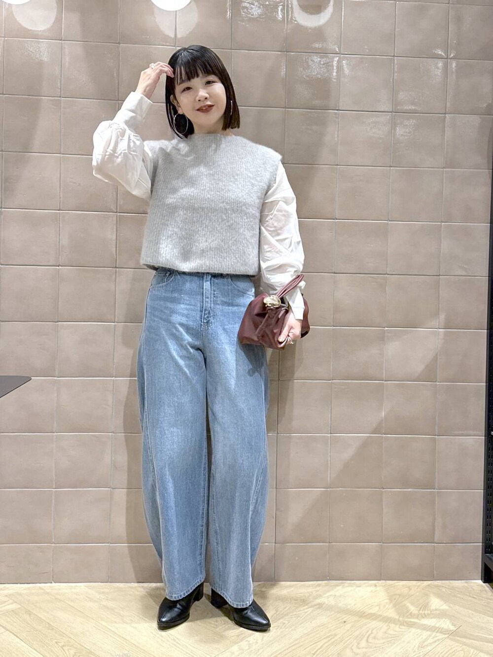 ブルー系のデニムパンツ、ホワイト系のシャツ/ブラウス、ブラック系のブーツを着用したレディースの秋コーディネートの2枚目の写真