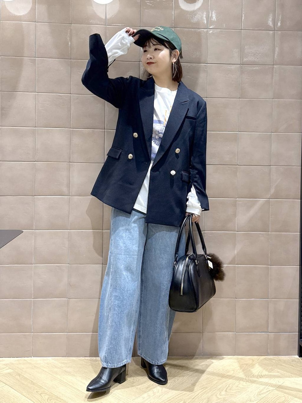 ブルー系のデニムパンツ、ブラック系のブーツ、ブルー系のテーラードジャケットを着用したレディースの秋コーディネートの6枚目の写真