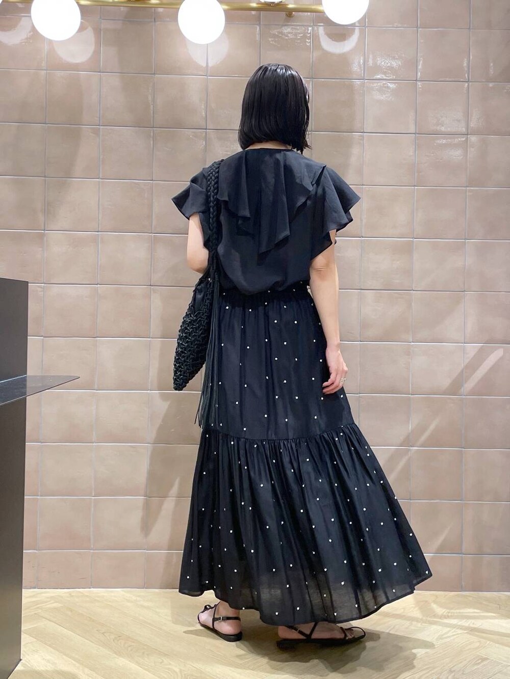 ブラック系のショルダーバッグ、ブラック系のサンダル、ブラック系のシャツ/ブラウスを着用したレディースの夏コーディネートの2枚目の写真