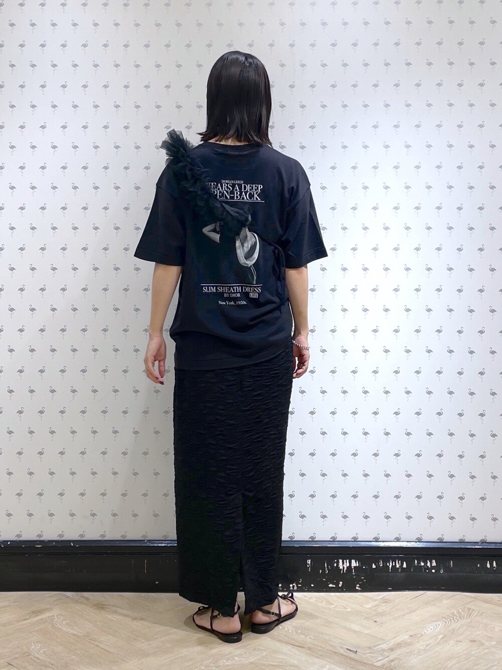 ブラック系のTシャツ/カットソー、ブラック系のスカート、ブラック系のサンダルを着用したレディースの夏コーディネートの2枚目の写真