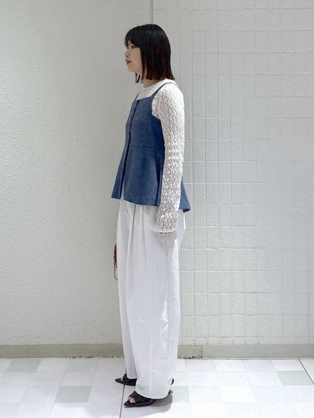 ホワイト系のTシャツ/カットソー、ブルー系のベスト、ブラック系のサンダルを着用したレディースの春コーディネートの4枚目の写真