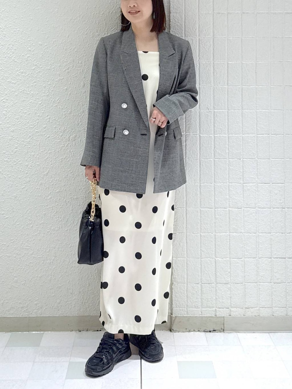 ブラック系のショルダーバッグ、ブラック系のテーラードジャケット、ホワイト系のワンピースを着用したレディースの冬コーディネートの2枚目の写真