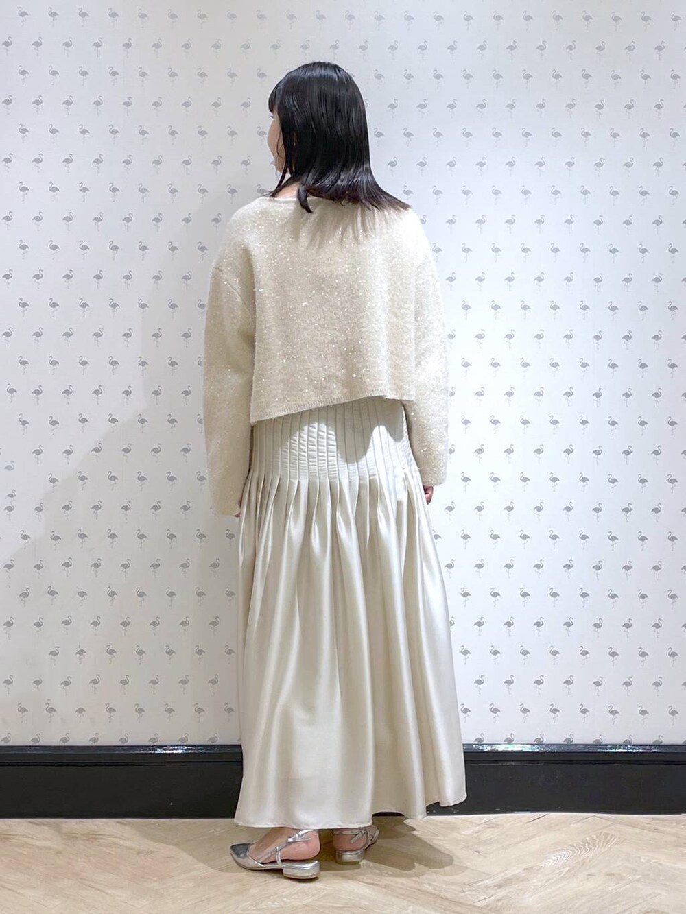 ホワイト系のニット/セーター、シルバー系のパンプス、ホワイト系のスカートを着用したレディースの冬コーディネートの3枚目の写真