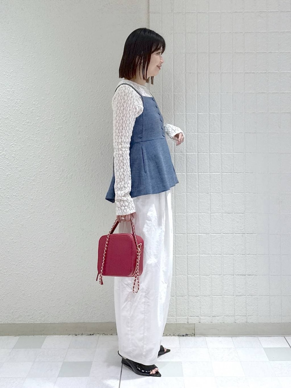 ホワイト系のTシャツ/カットソー、ブルー系のベスト、ブラック系のサンダルを着用したレディースの春コーディネートの2枚目の写真