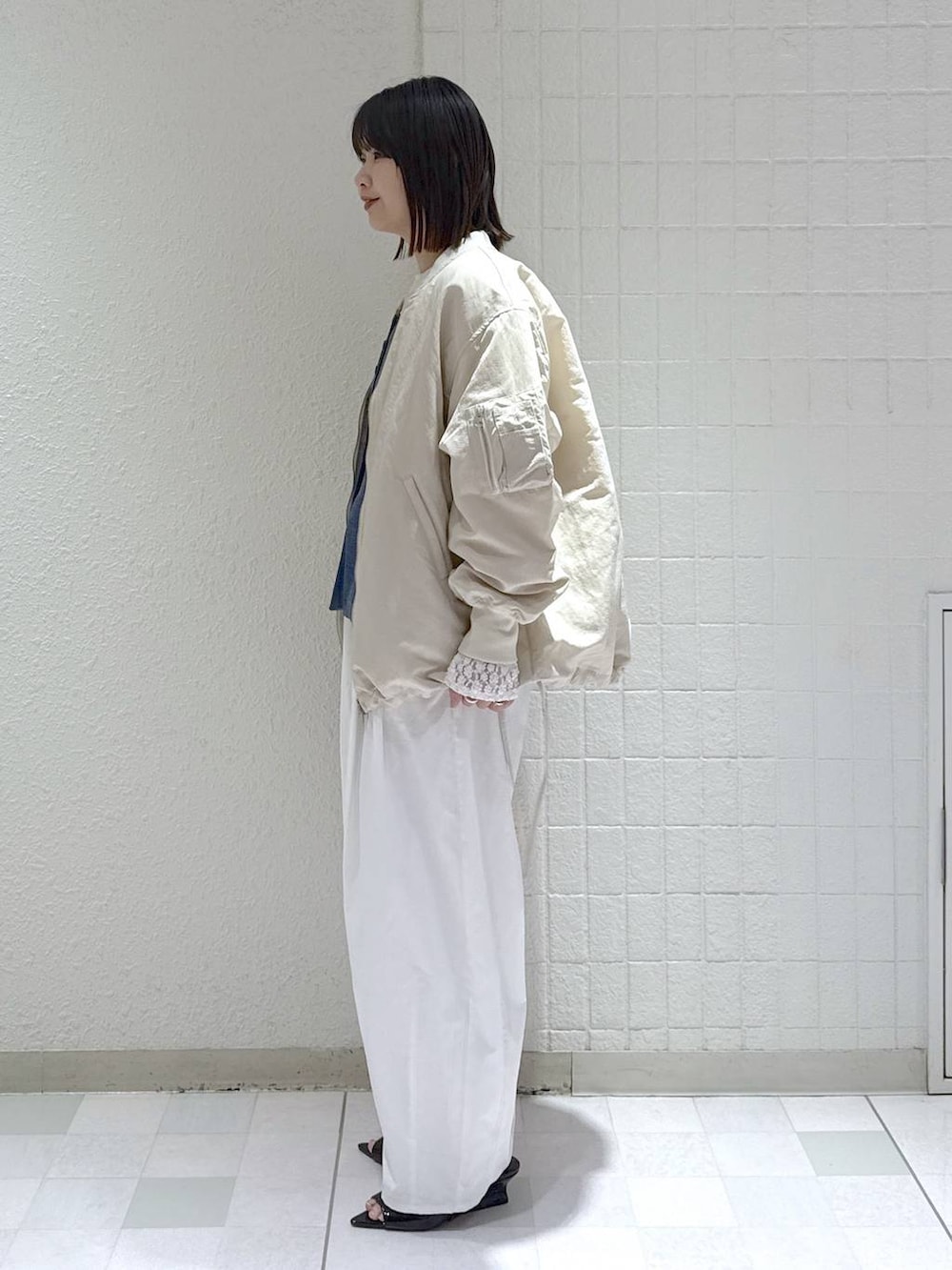 ベージュ系のMA-1、ホワイト系のTシャツ/カットソー、ブルー系のベストを着用したレディースの春コーディネートの5枚目の写真