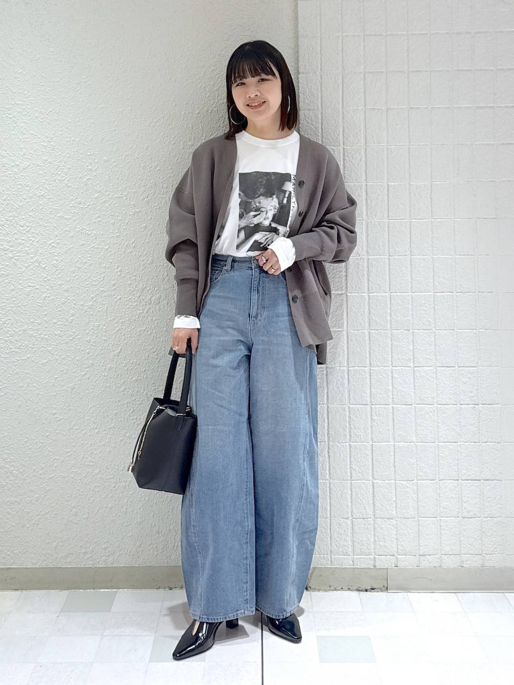 ブルー系のデニムパンツ、グレー系のカーディガン/ボレロ、ブラック系のその他シューズを着用したレディースの冬コーディネートの2枚目の写真