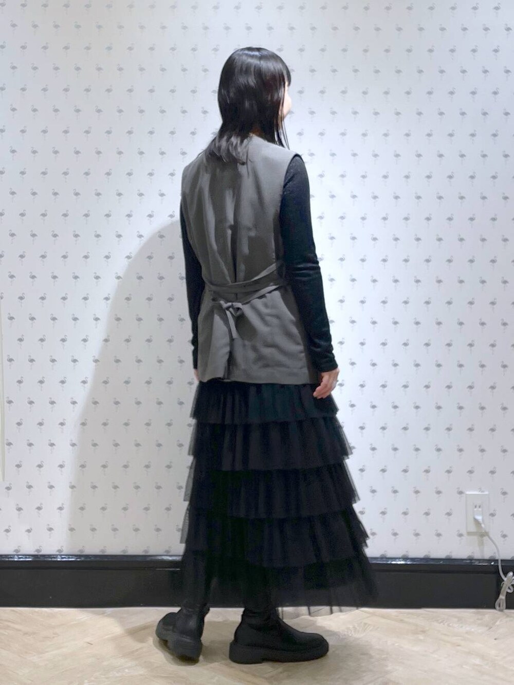 ブラック系のTシャツ/カットソー、グレー系のベスト、ブラック系のスカートを着用したレディースの冬コーディネートの4枚目の写真