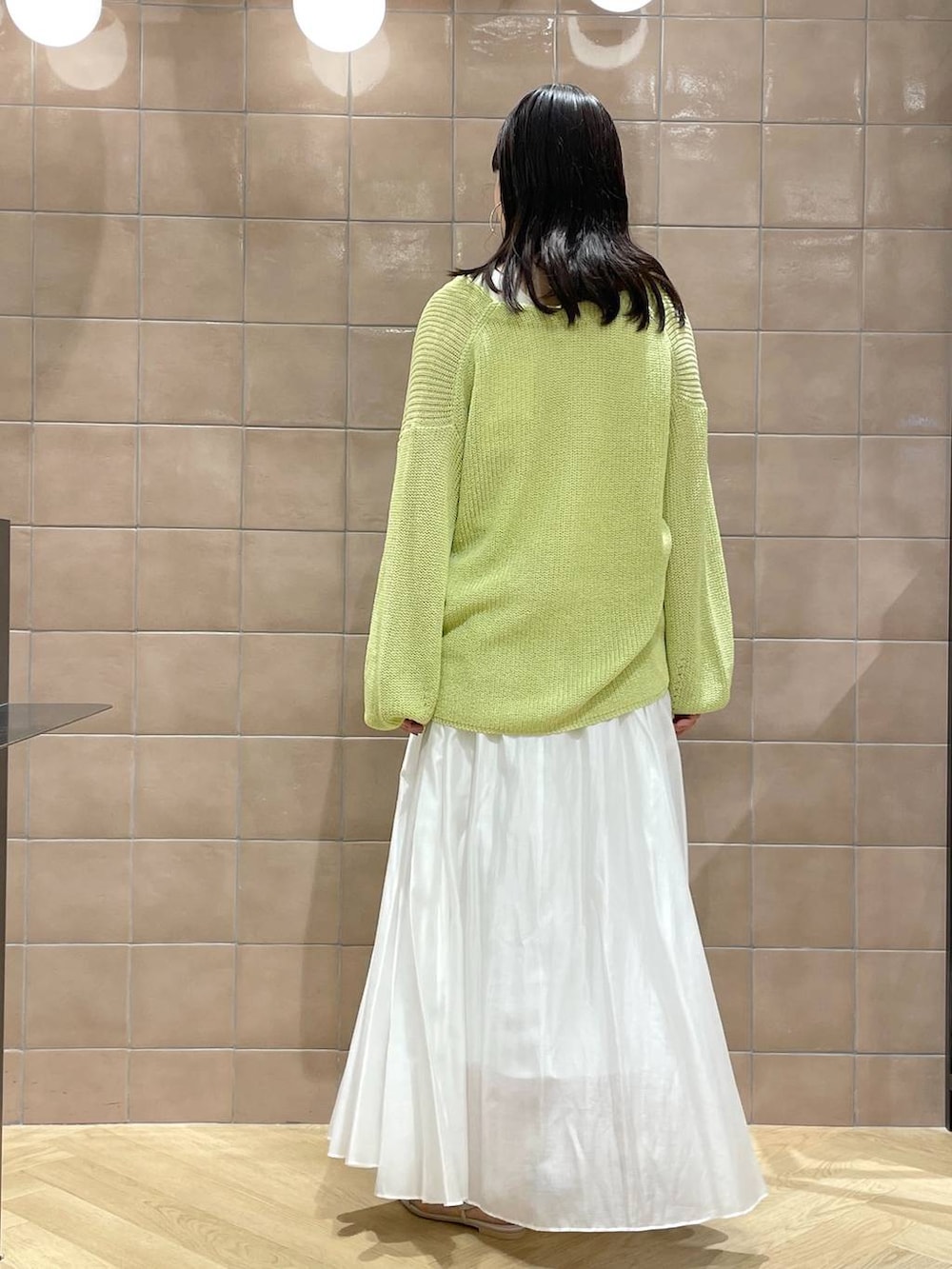 ホワイト系のタンクトップ、ホワイト系のサンダル、イエロー系のカーディガン/ボレロを着用したレディースの春コーディネートの3枚目の写真