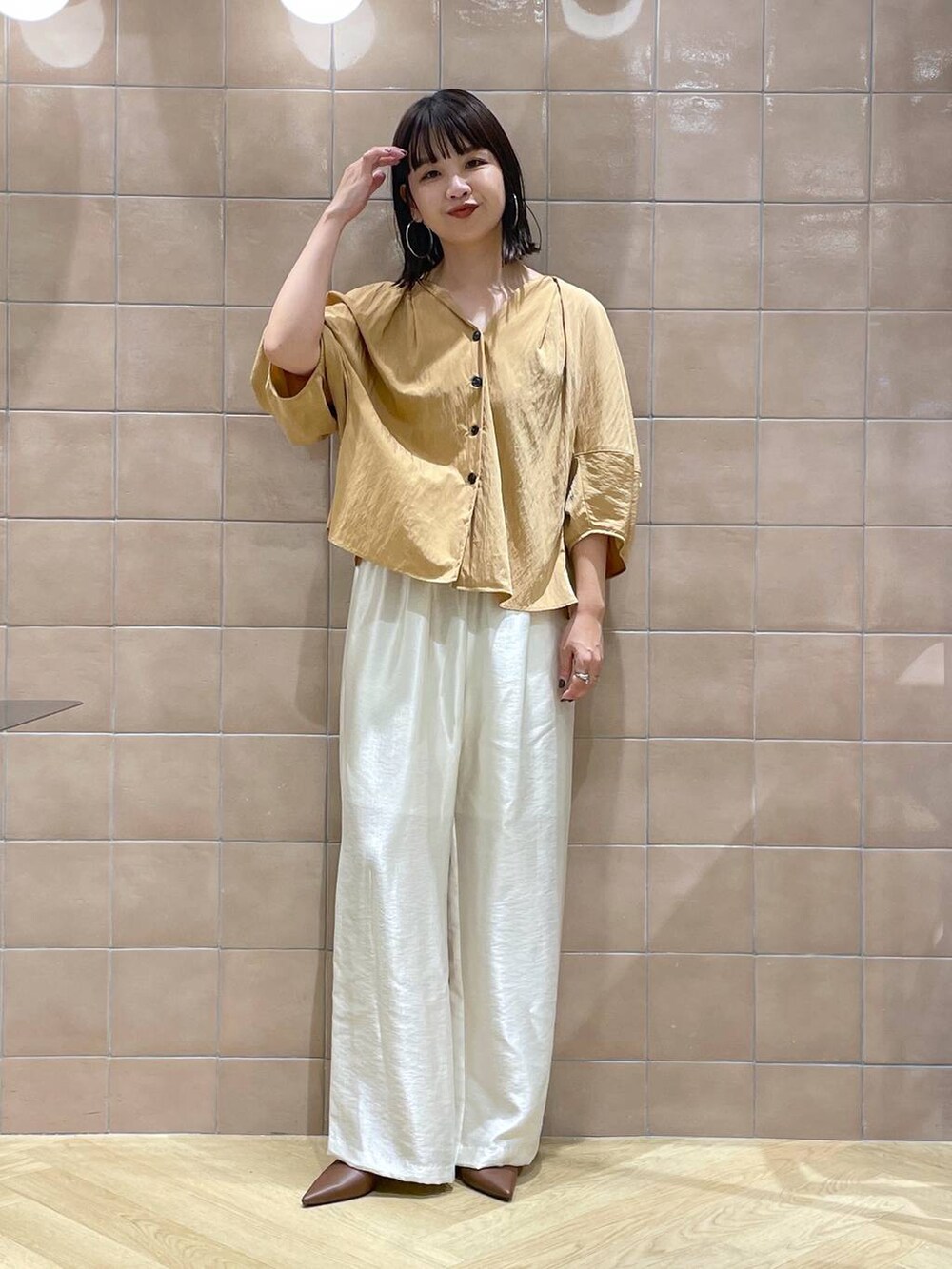 ブラウン系のパンプス、ホワイト系のその他パンツ、オレンジ系のシャツ/ブラウスを着用したレディースの夏コーディネートの4枚目の写真