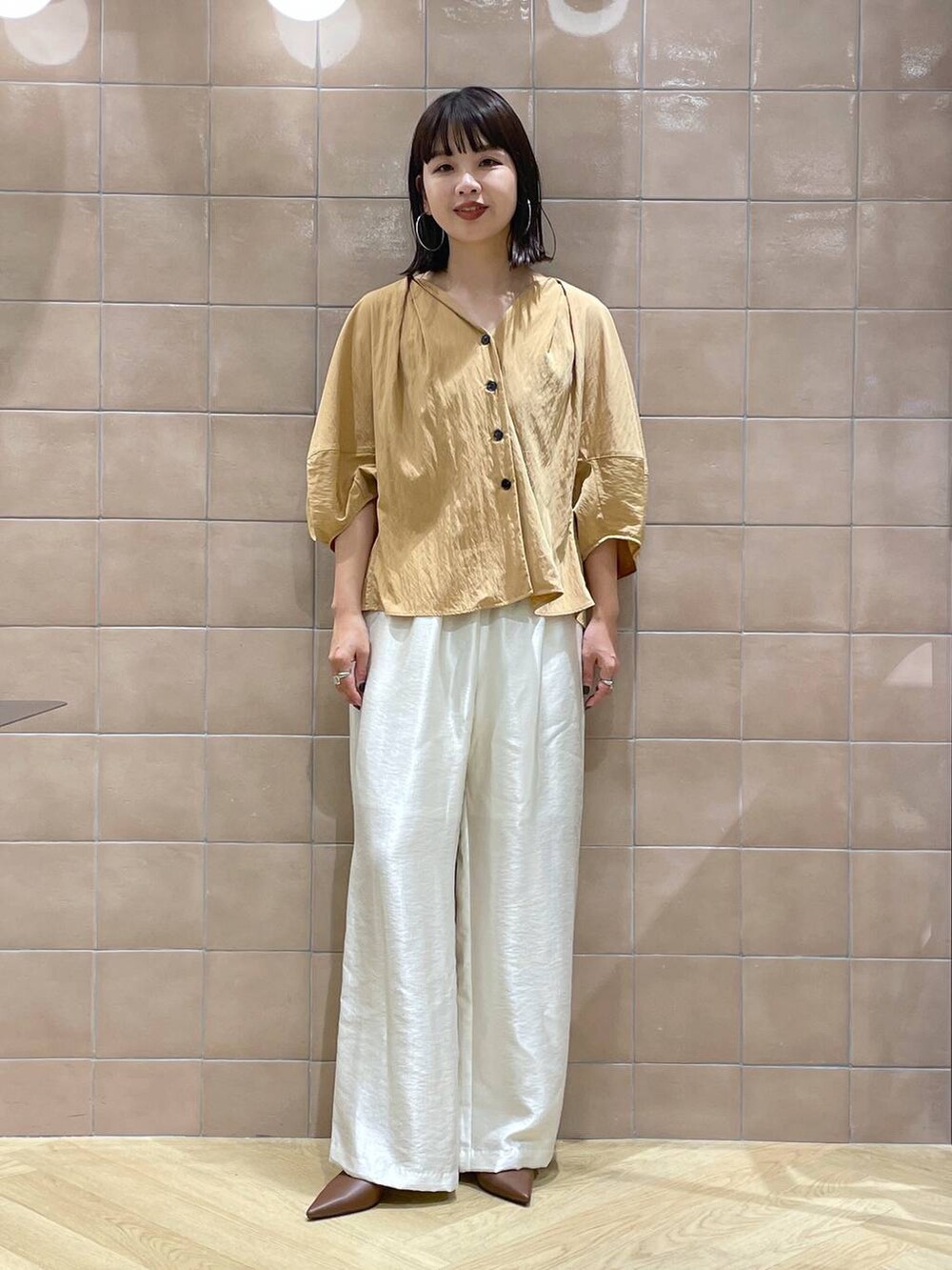 ブラウン系のパンプス、ホワイト系のその他パンツ、オレンジ系のシャツ/ブラウスを着用したレディースの夏コーディネートの2枚目の写真