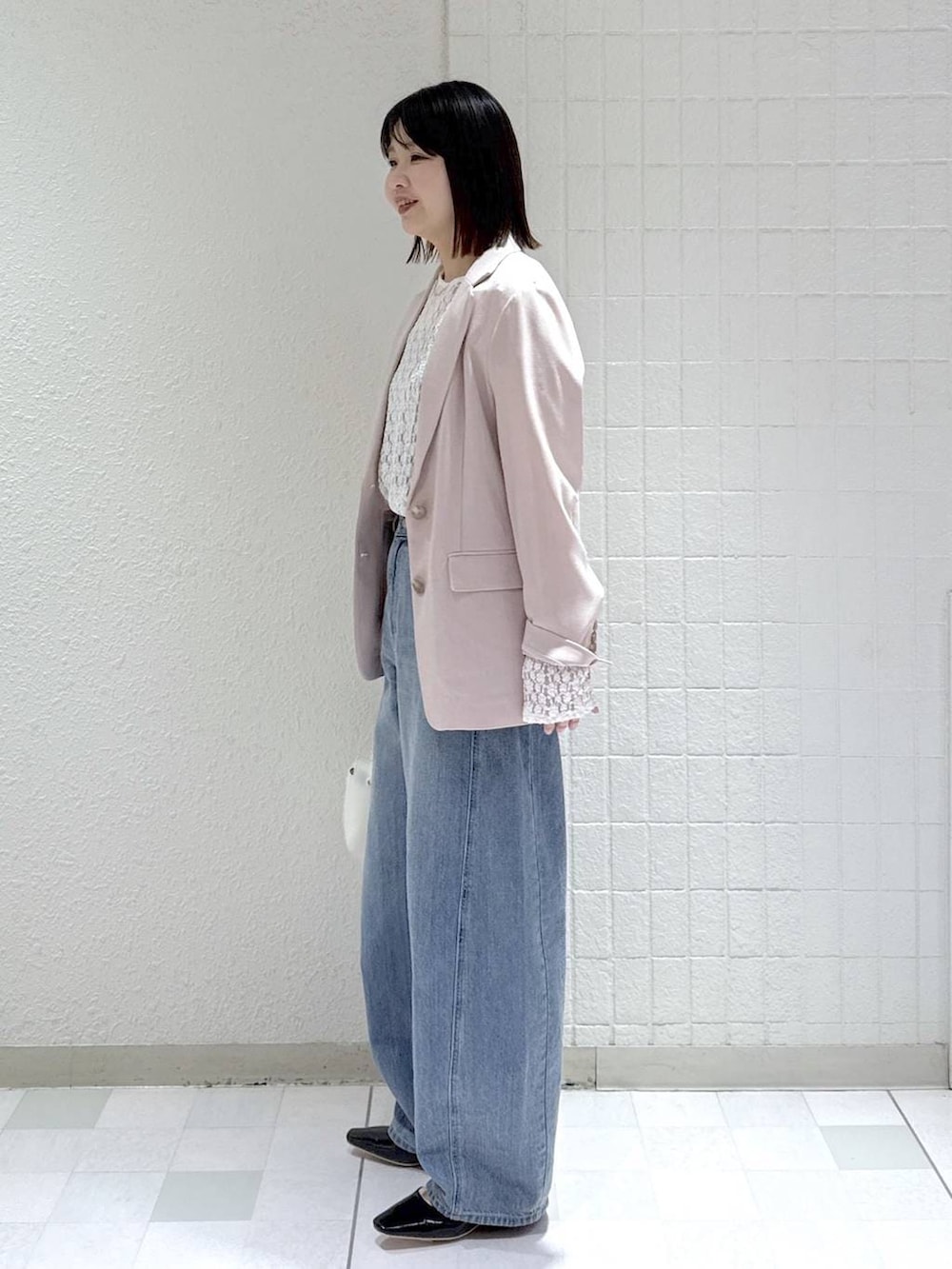 ブルー系のデニムパンツ、ホワイト系のTシャツ/カットソー、ホワイト系のショルダーバッグを着用したレディースの春コーディネートの5枚目の写真