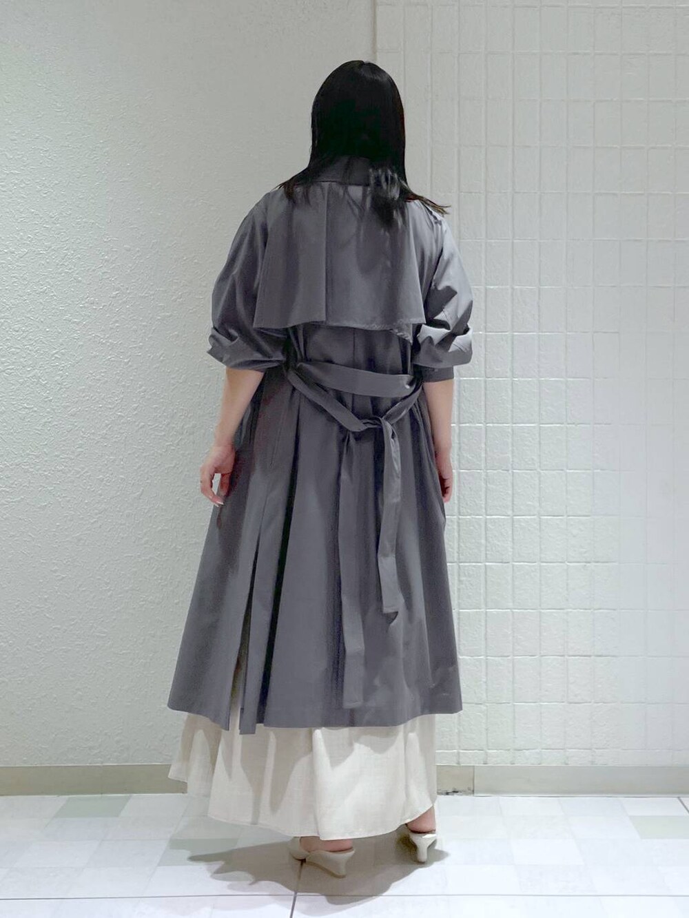 ホワイト系のサンダル、ホワイト系のニット/セーター、ベージュ系のスカートを着用したレディースの春コーディネートの2枚目の写真