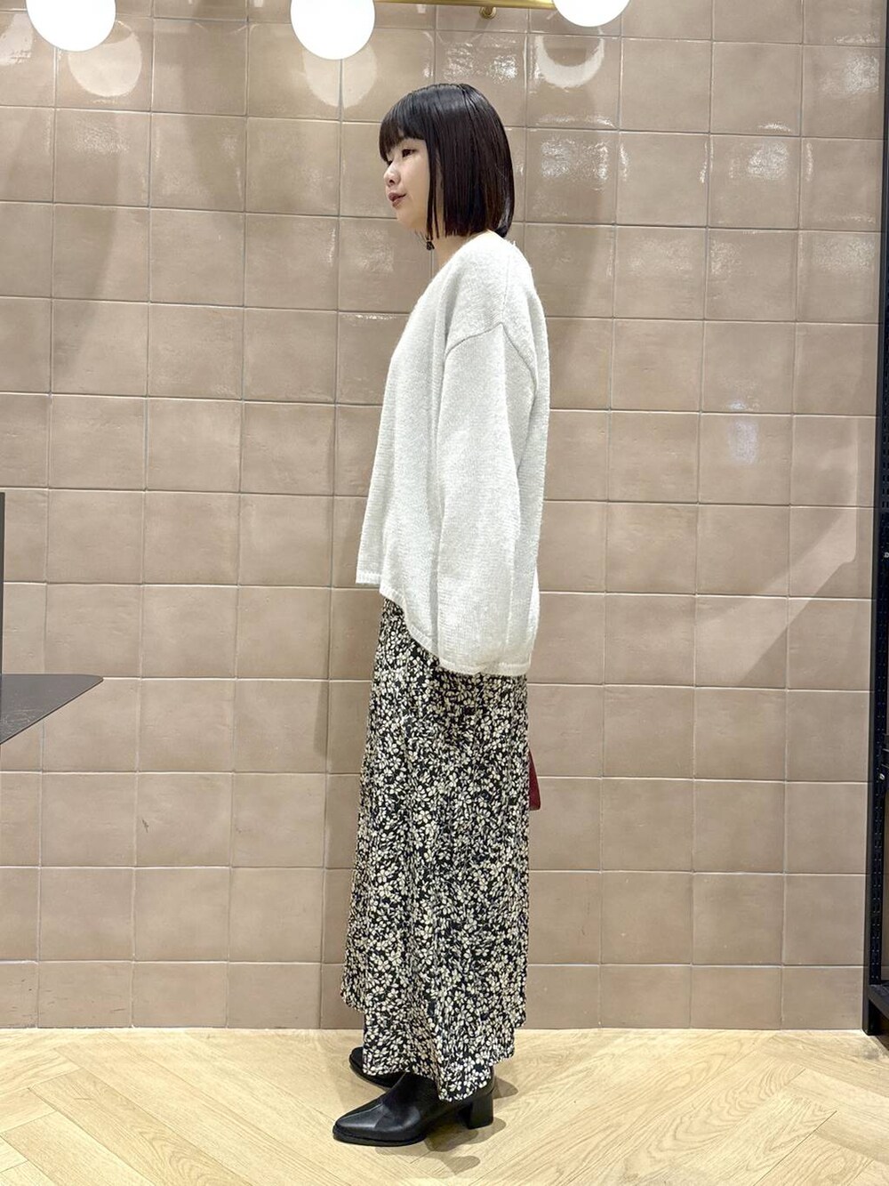 ブラック系のブーツ、レッド系のショルダーバッグ、グレー系のニット/セーターを着用したレディースの冬コーディネートの4枚目の写真