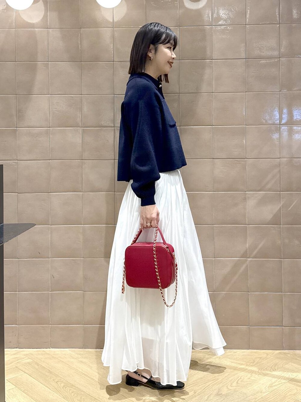 ホワイト系のスカート、ブルー系のカーディガン/ボレロ、ブラック系のその他シューズを着用したレディースの冬コーディネートの3枚目の写真