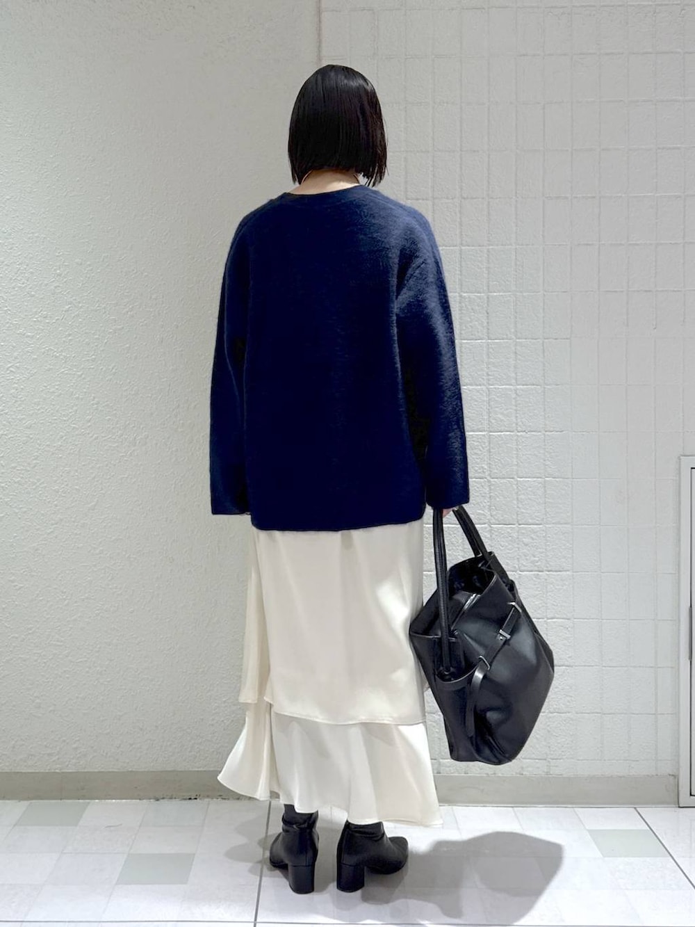 ブルー系のカーディガン/ボレロ、ブラック系のブーツ、ホワイト系のワンピースを着用したレディースの秋コーディネートの4枚目の写真
