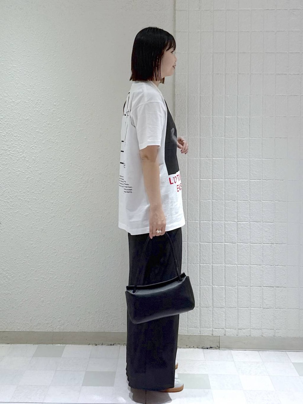 シルバー系のスニーカー、ブラック系のテーラードジャケット、ブラック系のショルダーバッグを着用したレディースの冬コーディネートの7枚目の写真