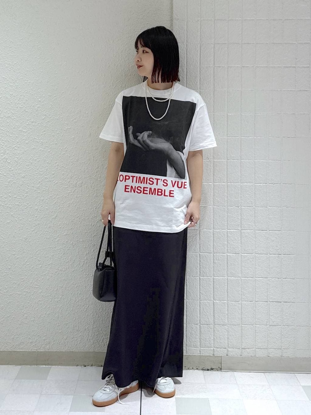 シルバー系のスニーカー、ブラック系のテーラードジャケット、ブラック系のショルダーバッグを着用したレディースの冬コーディネートの6枚目の写真