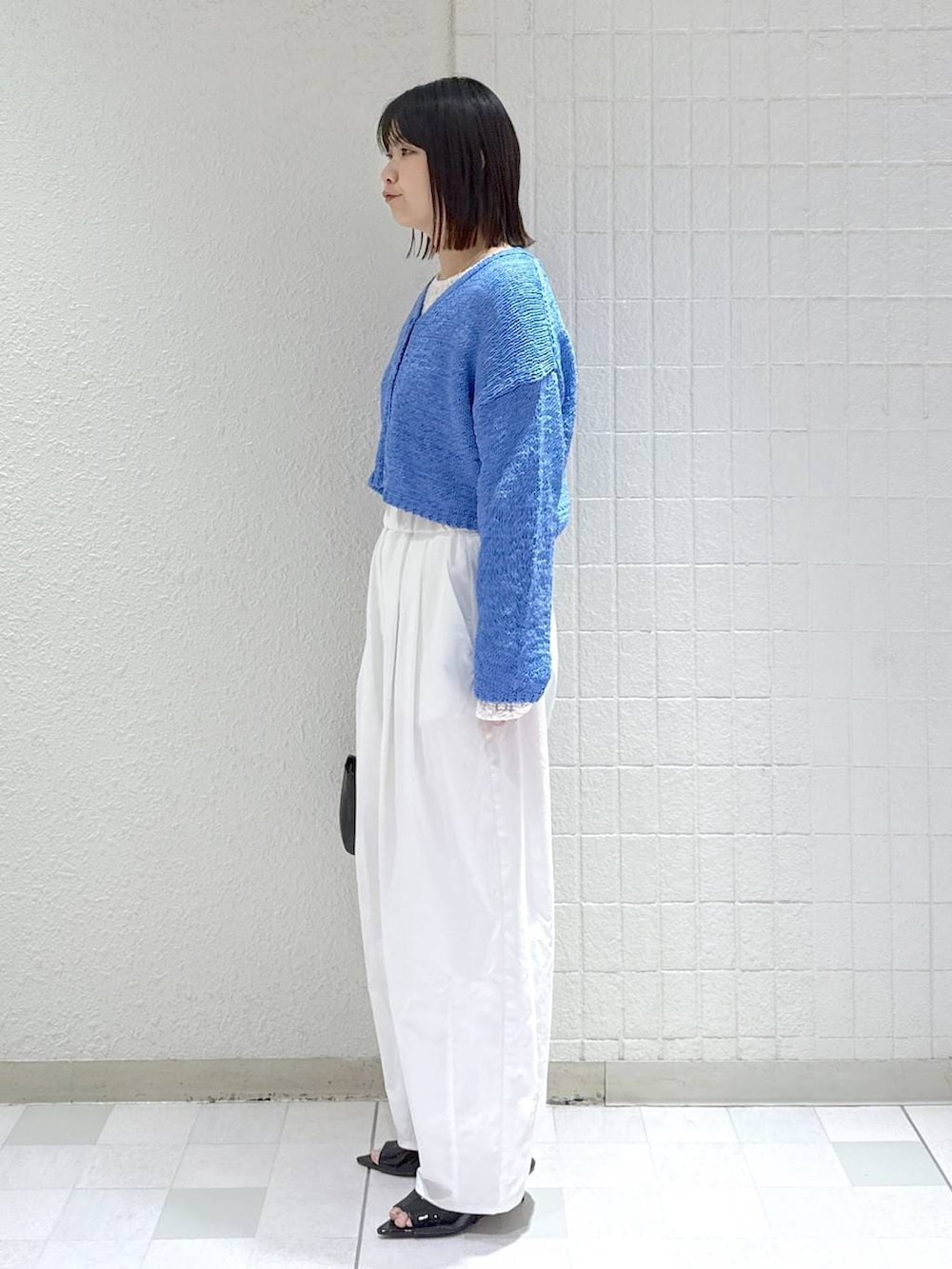 ホワイト系のTシャツ/カットソー、ブラック系のショルダーバッグ、ブルー系のカーディガン/ボレロを着用したレディースの春コーディネートの5枚目の写真