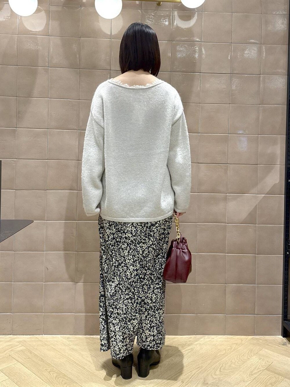 ブラック系のブーツ、レッド系のショルダーバッグ、グレー系のニット/セーターを着用したレディースの冬コーディネートの3枚目の写真