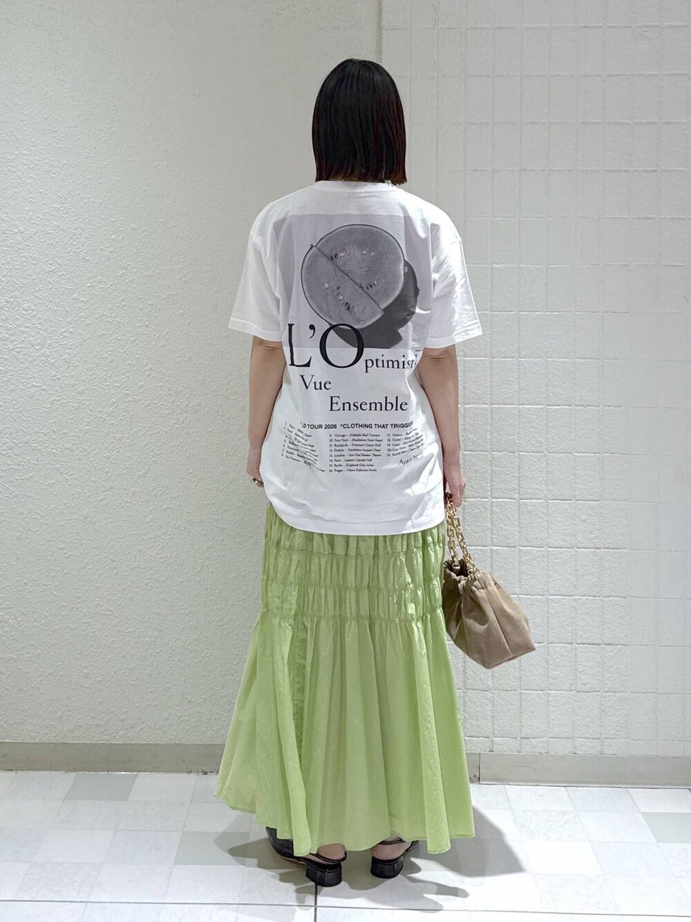 ベージュ系のショルダーバッグ、グリーン系のスカート、ブラック系のその他シューズを着用したレディースの冬コーディネートの3枚目の写真