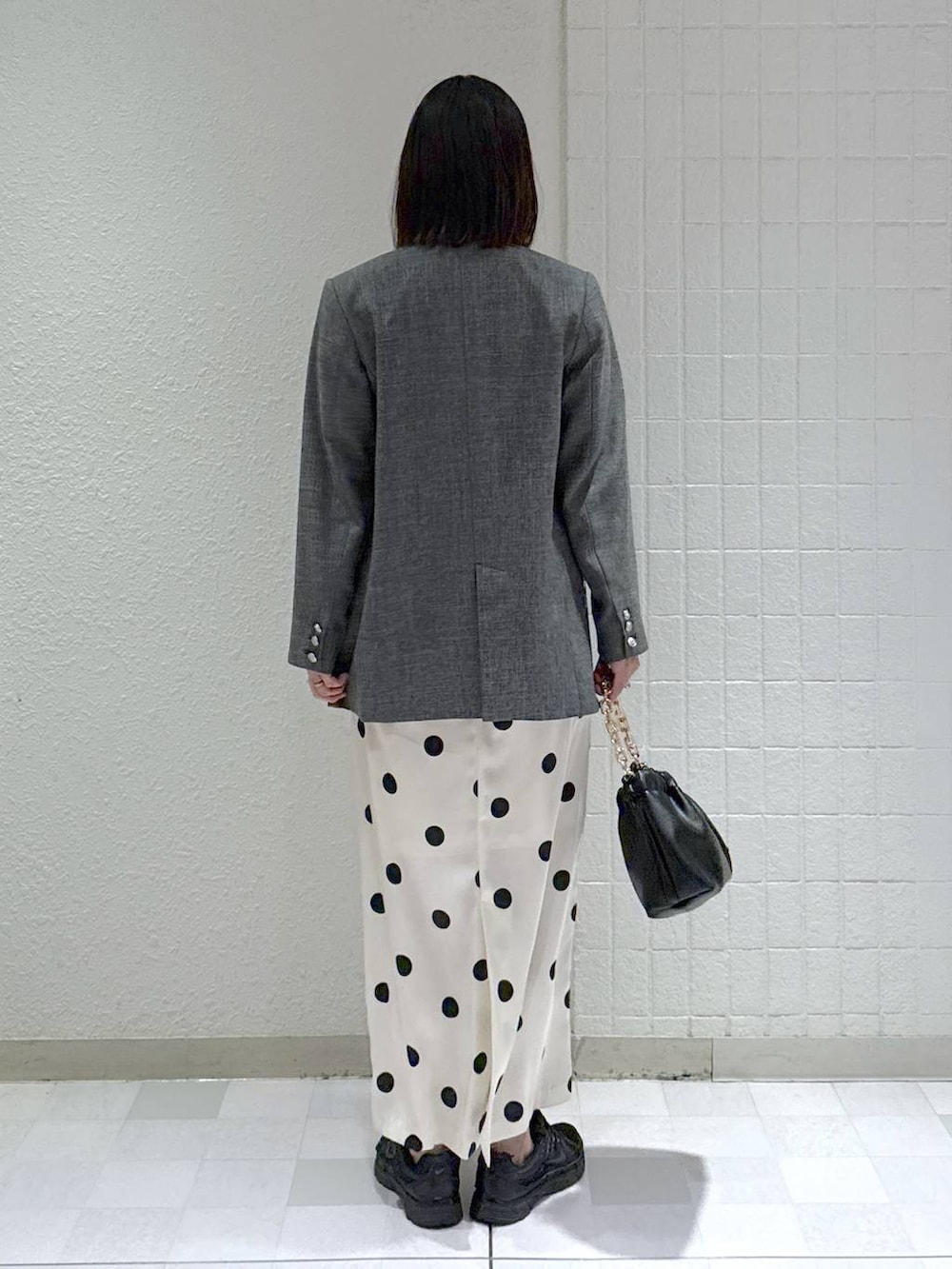 ブラック系のショルダーバッグ、ブラック系のテーラードジャケット、ホワイト系のワンピースを着用したレディースの冬コーディネートの4枚目の写真