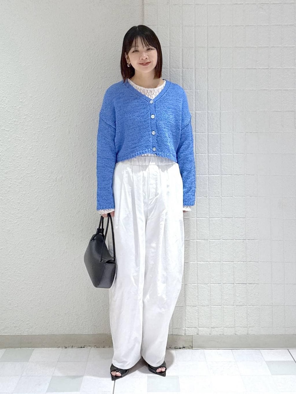 ホワイト系のTシャツ/カットソー、ブラック系のショルダーバッグ、ブルー系のカーディガン/ボレロを着用したレディースの春コーディネートの2枚目の写真