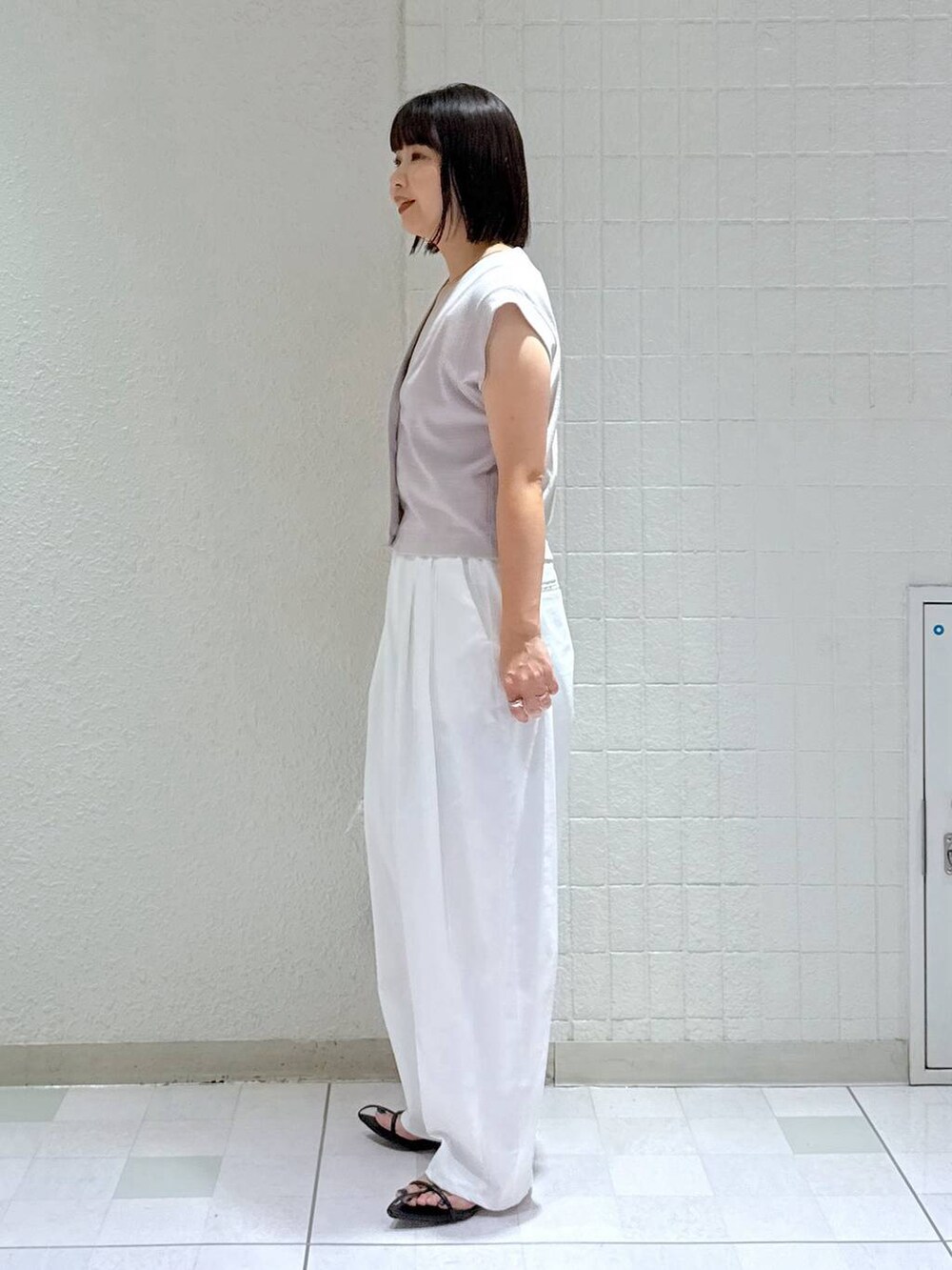 ホワイト系のボストンバッグ、ブラック系のサンダル、ホワイト系のその他パンツを着用したレディースの夏コーディネートの4枚目の写真