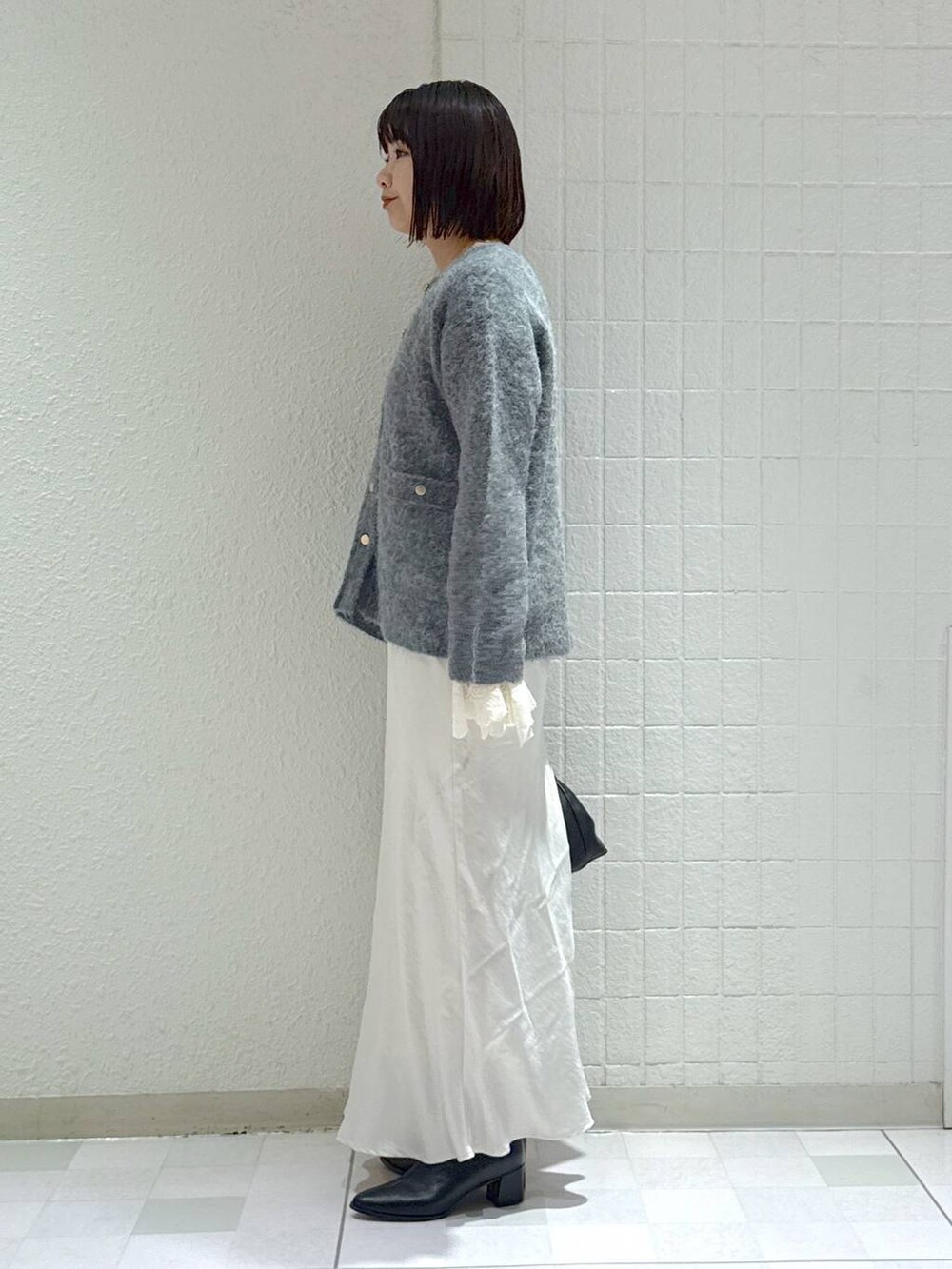 ブラック系のブーツ、グレー系のカーディガン/ボレロ、ホワイト系のスカートを着用したレディースの秋コーディネートの4枚目の写真