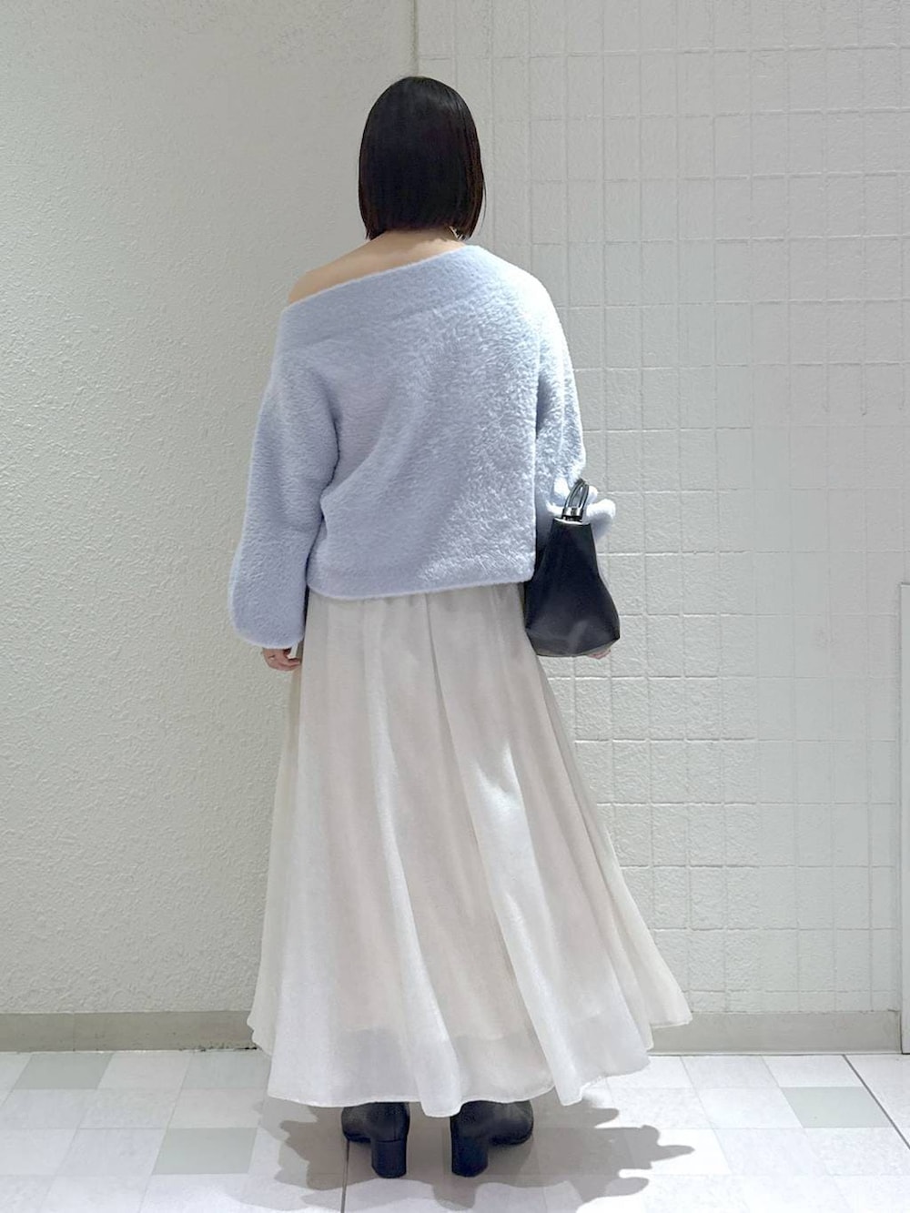 ブラック系のブーツ、ブラック系のショルダーバッグ、ブルー系のニット/セーターを着用したレディースの冬コーディネートの4枚目の写真