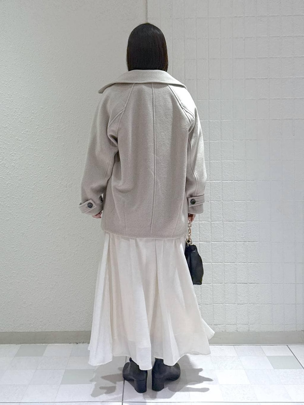 ベージュ系のピーコート、ブラック系のブーツ、ブラウン系のニット/セーターを着用したレディースの冬コーディネートの4枚目の写真