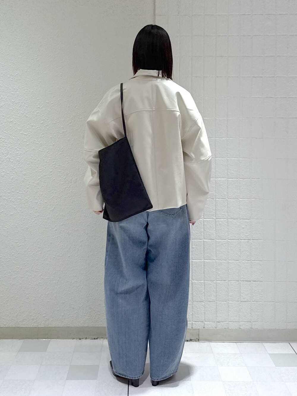 ブルー系のデニムパンツ、ホワイト系のブルゾン、ブラック系のパンプスを着用したレディースの春コーディネートの4枚目の写真