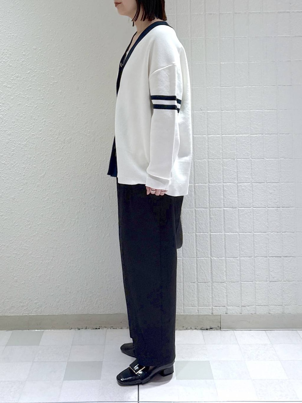 ブラック系のカーディガン/ボレロ、ホワイト系のタンクトップ、ブラック系のローファーを着用したレディースの冬コーディネートの4枚目の写真