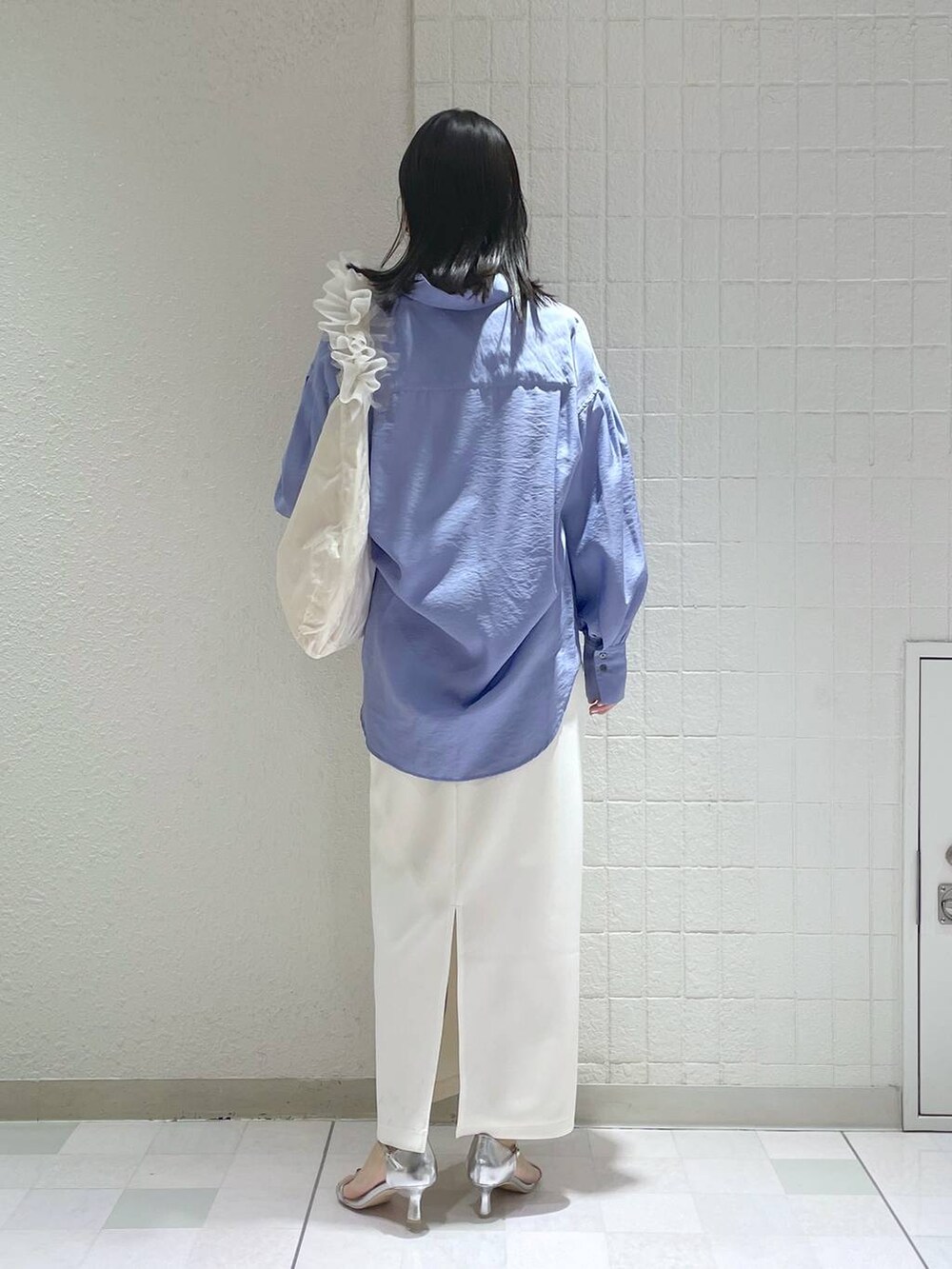 ブルー系のシャツ/ブラウス、シルバー系のサンダル、ホワイト系のショルダーバッグを着用したレディースの春コーディネートの3枚目の写真
