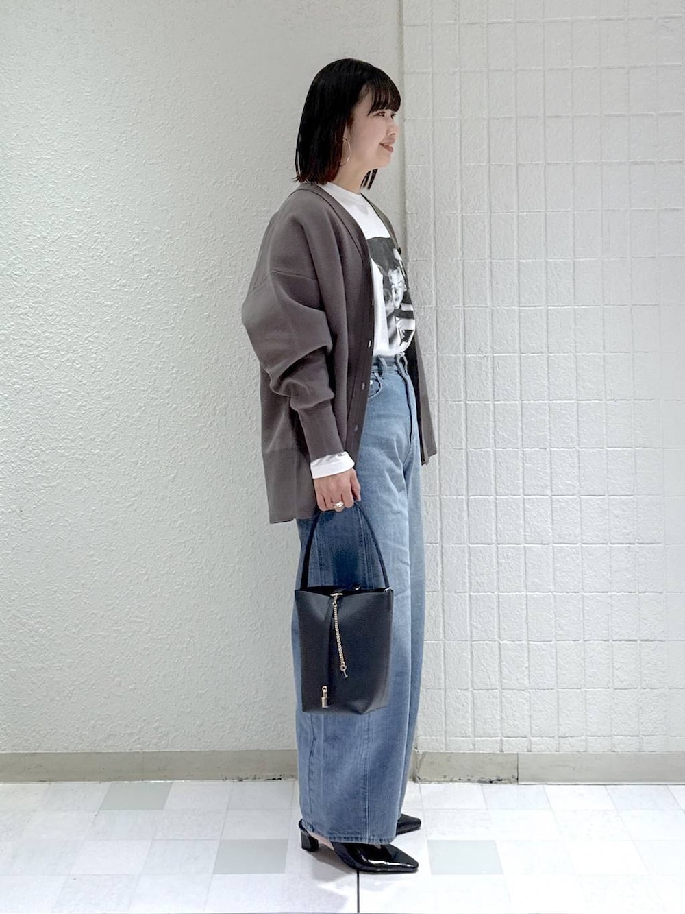 ブルー系のデニムパンツ、グレー系のカーディガン/ボレロ、ブラック系のその他シューズを着用したレディースの冬コーディネートの3枚目の写真