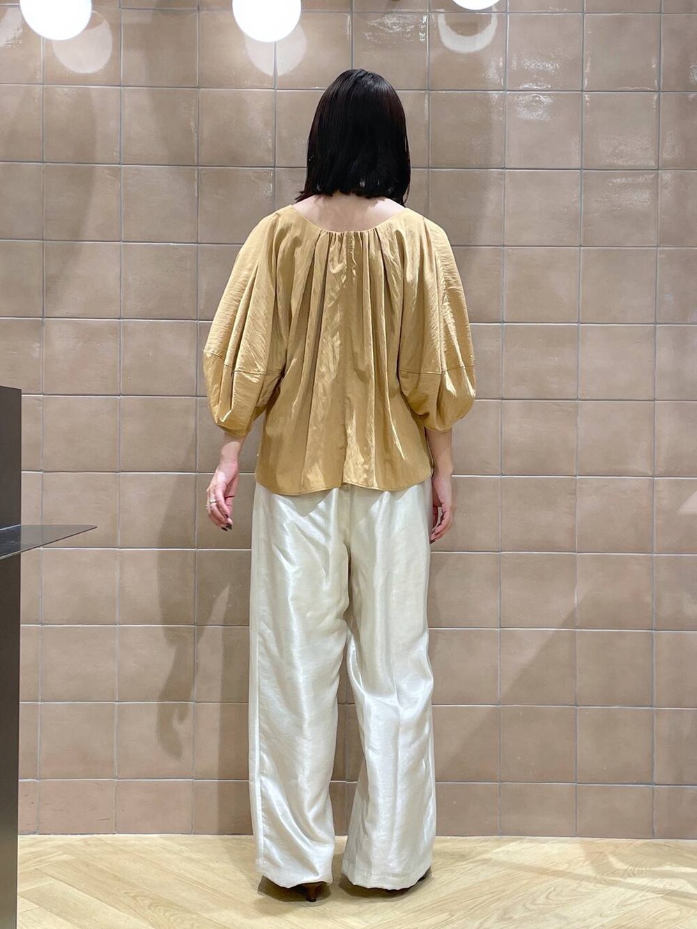 ブラウン系のパンプス、ホワイト系のその他パンツ、オレンジ系のシャツ/ブラウスを着用したレディースの夏コーディネートの5枚目の写真