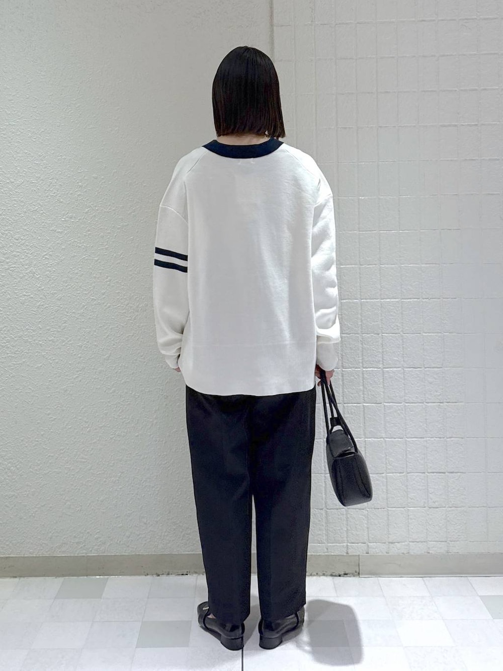 ブラック系のカーディガン/ボレロ、ホワイト系のタンクトップ、ブラック系のローファーを着用したレディースの冬コーディネートの3枚目の写真