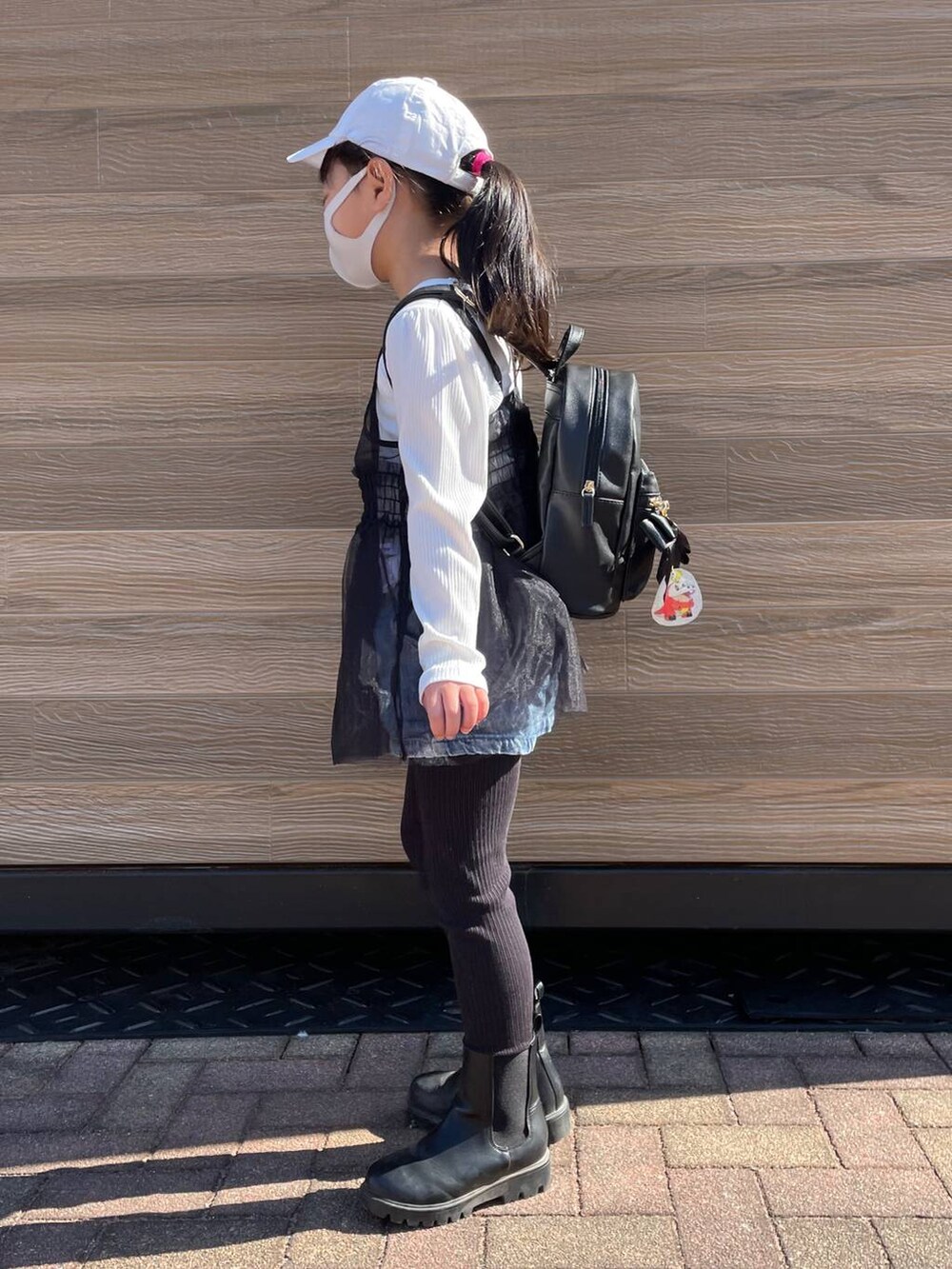 ブラック系のブーツ、ブラック系のTシャツ/カットソー、ブラック系のバックパック/リュックを着用したキッズの冬コーディネートの3枚目の写真