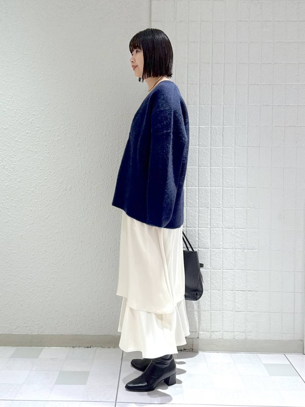 ブルー系のカーディガン/ボレロ、ブラック系のブーツ、ホワイト系のワンピースを着用したレディースの秋コーディネートの5枚目の写真