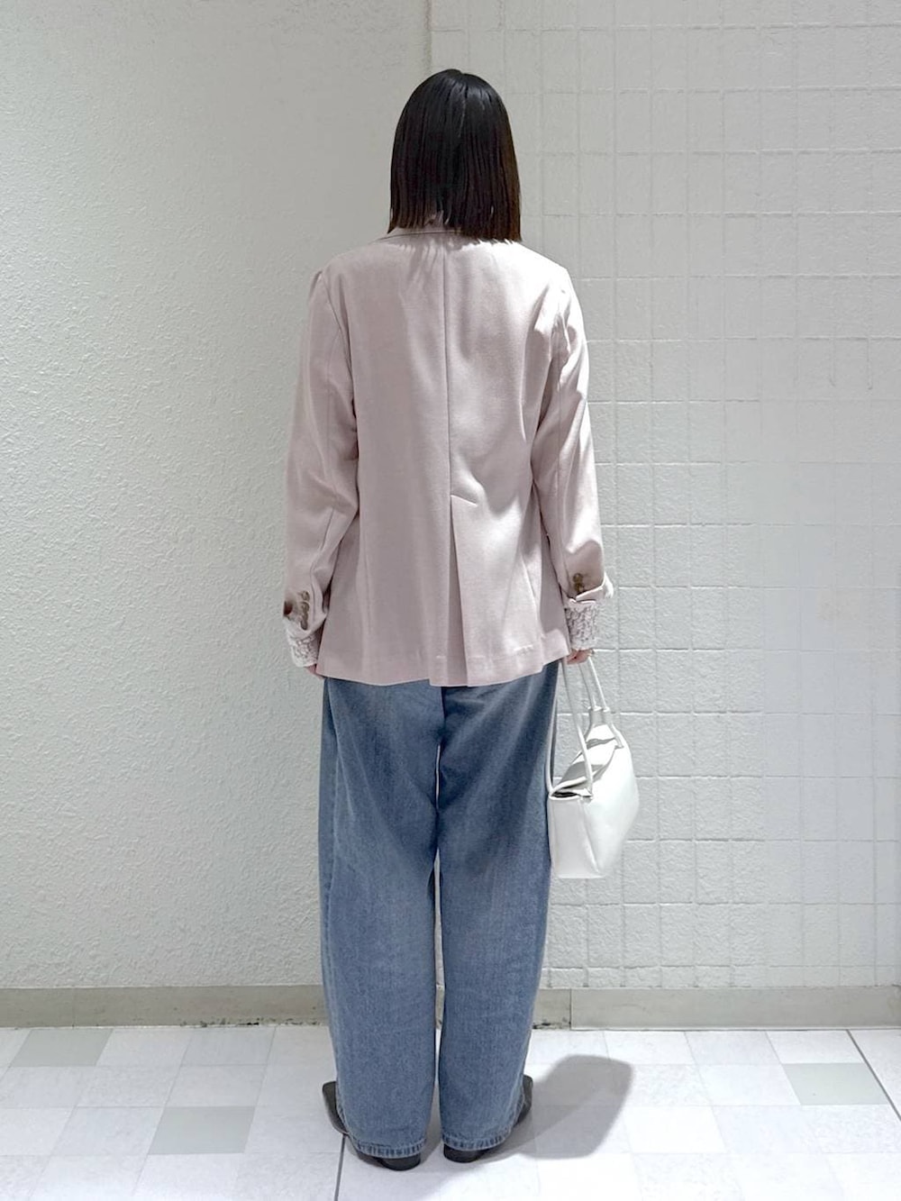 ブルー系のデニムパンツ、ホワイト系のTシャツ/カットソー、ホワイト系のショルダーバッグを着用したレディースの春コーディネートの4枚目の写真