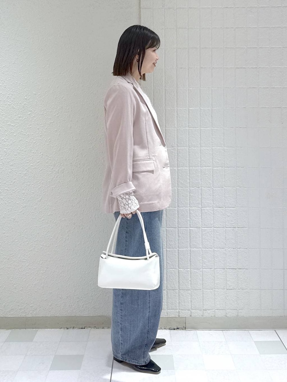 ブルー系のデニムパンツ、ホワイト系のTシャツ/カットソー、ホワイト系のショルダーバッグを着用したレディースの春コーディネートの3枚目の写真