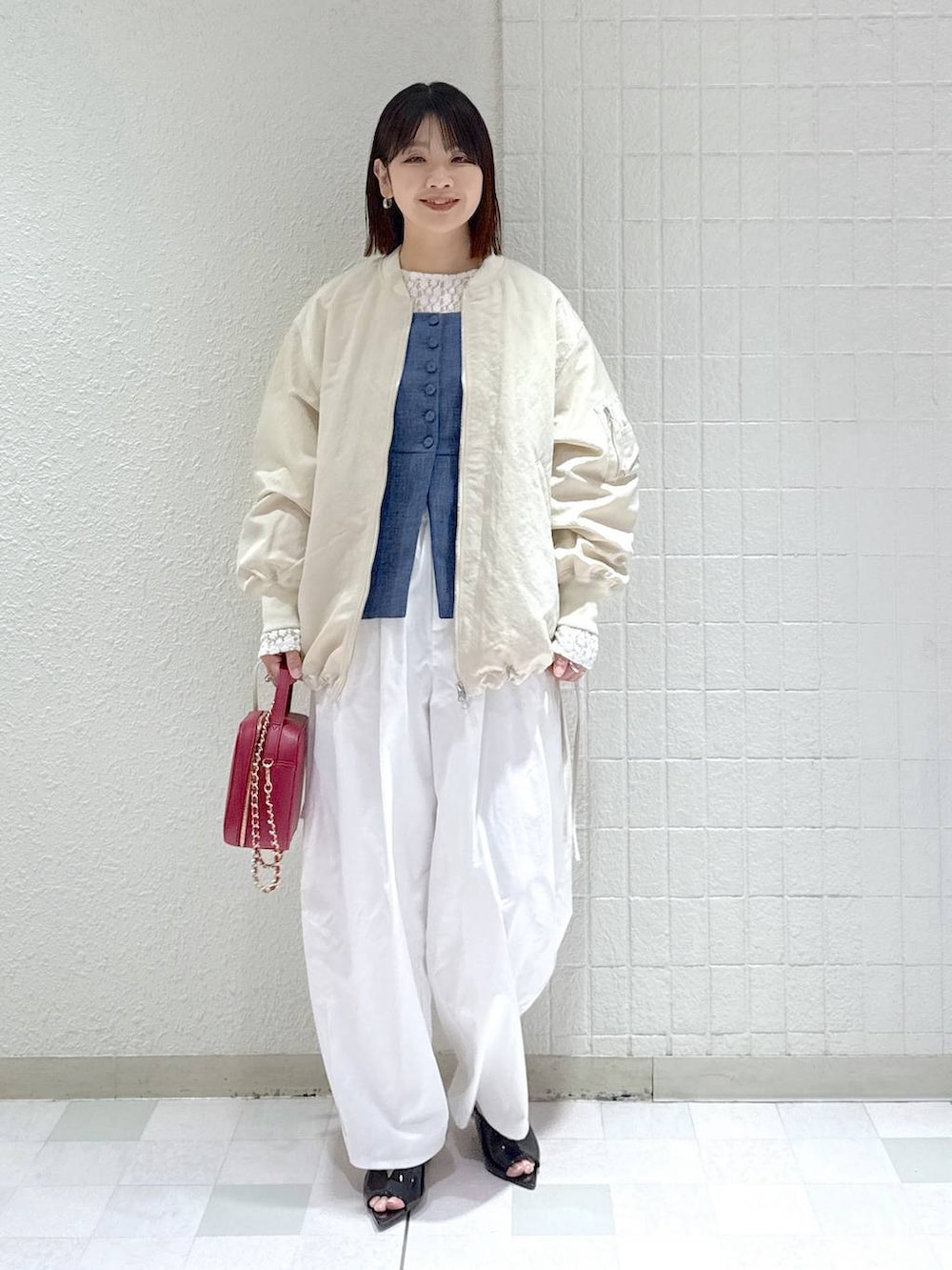 ベージュ系のMA-1、ホワイト系のTシャツ/カットソー、ブルー系のベストを着用したレディースの春コーディネートの2枚目の写真