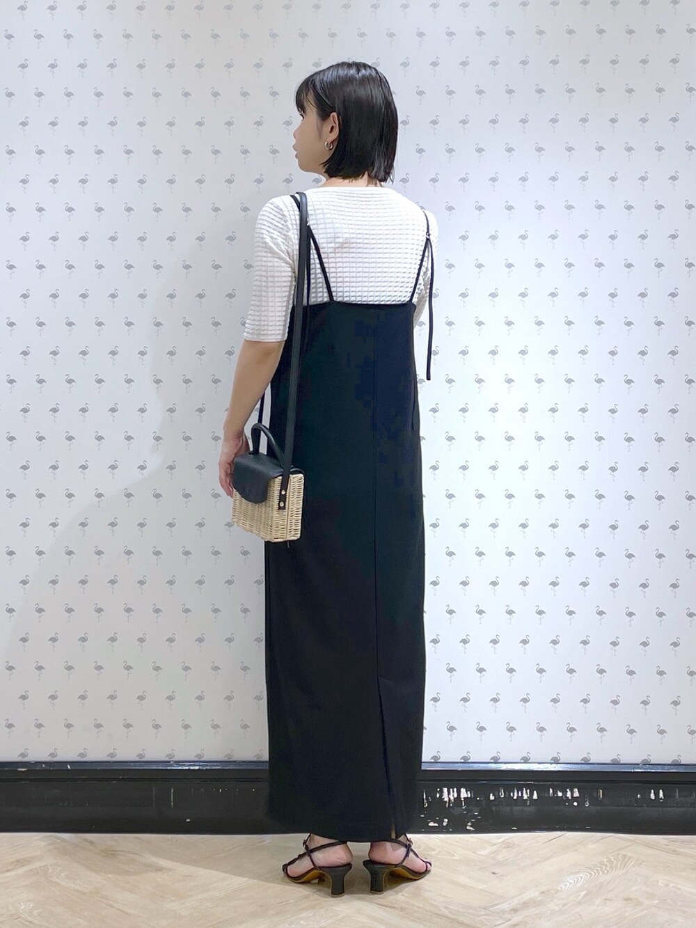 ホワイト系のTシャツ/カットソー、ブラック系のワンピース、ブラック系のサンダルを着用したレディースの春コーディネートの2枚目の写真